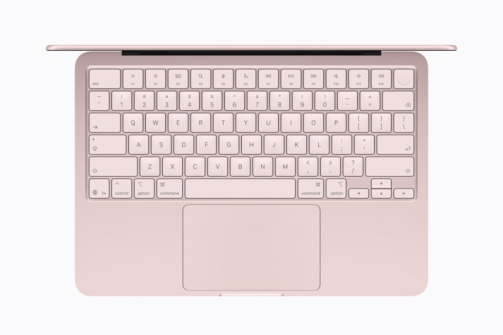 The keyboard and trackpad of a blush MacBook Neo, viewed from above